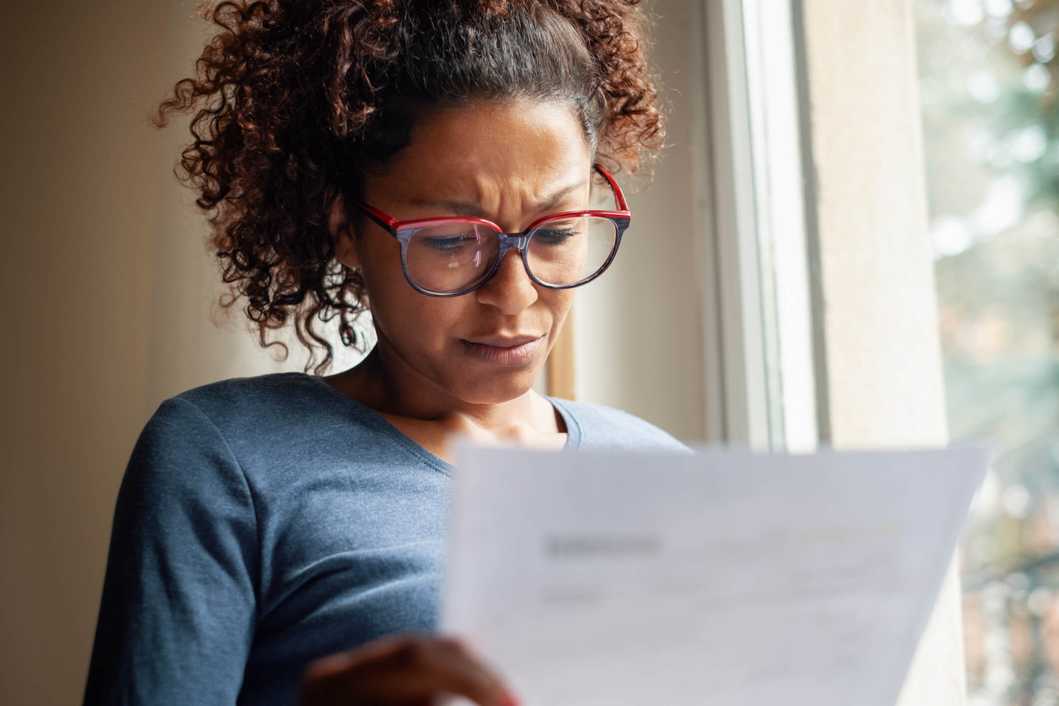 Worried woman reading near window